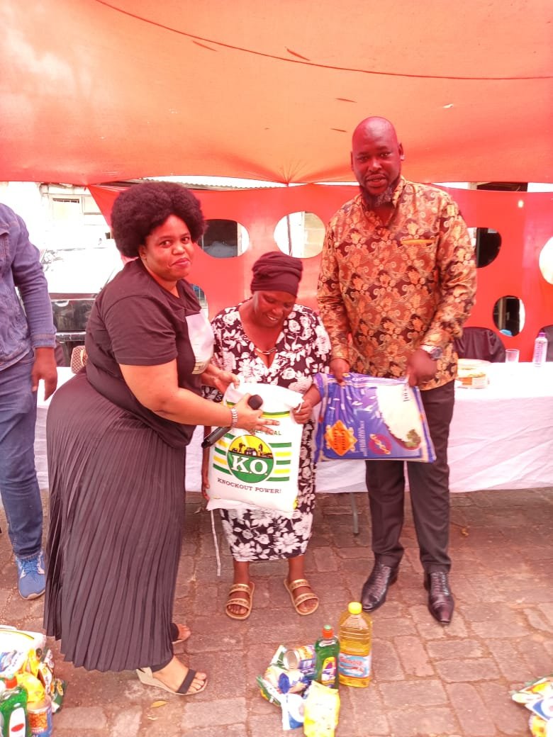 Mafuthi team members handing a bag of rice and food parcels to a community member